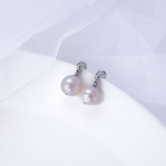 Minimalist stud earrings with real freshwater pearl drops on a white background