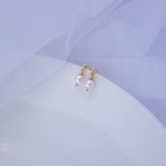 Small freshwater pearl stud earrings with 18K gold accents on a light background
