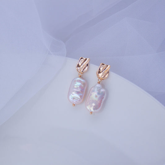 Gold baroque pearl drop earrings with irregular freshwater pearls on a white background.