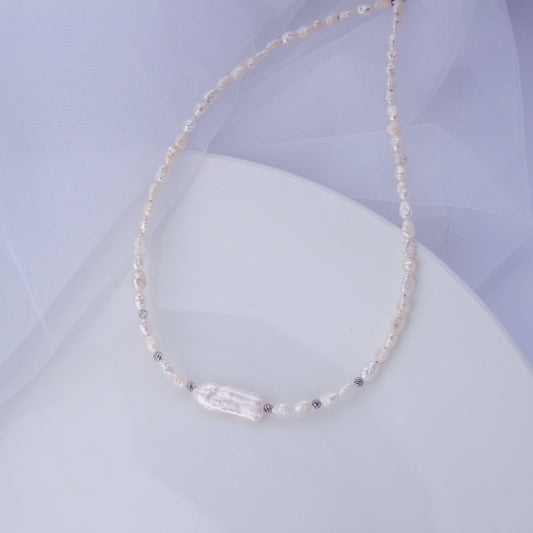 Freshwater pearl choker necklace with a long Biwa baroque pearl on a soft background