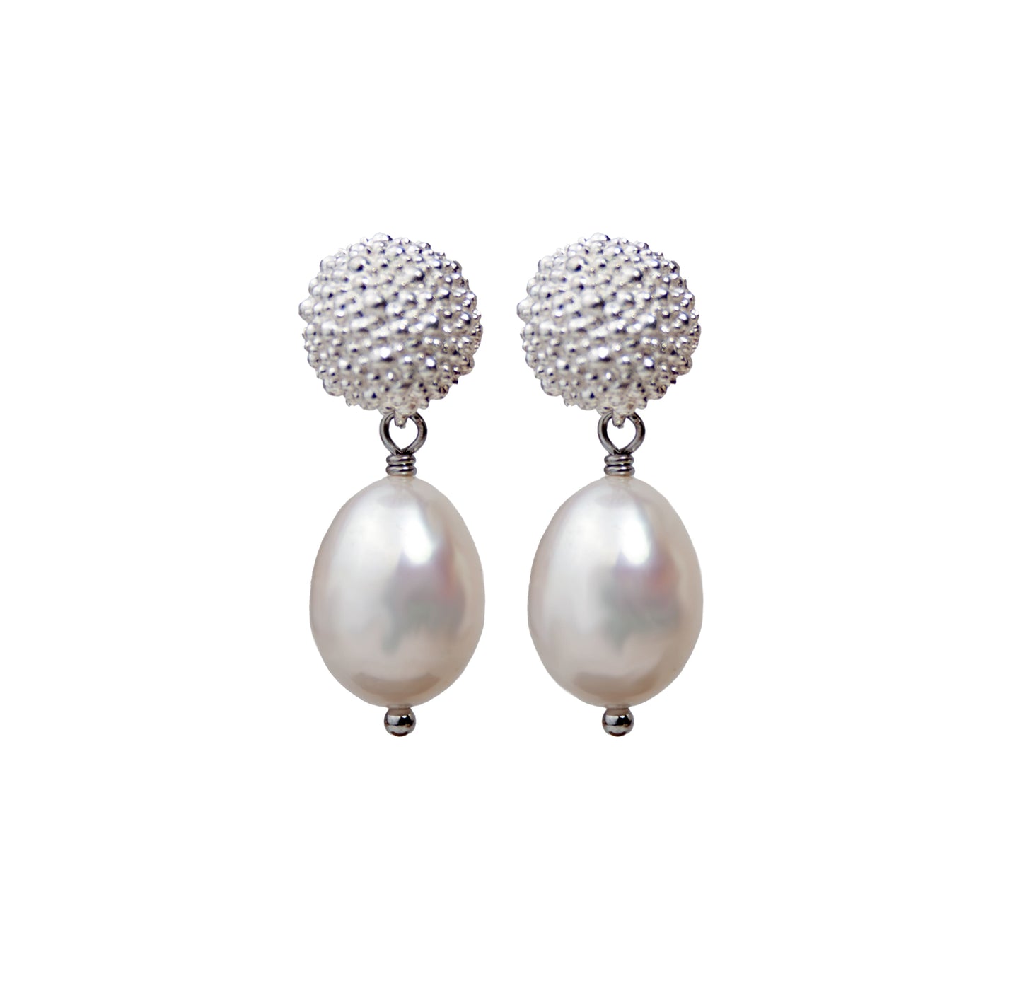 Pair of earrings with pearl drops and textured silver tops on a white background