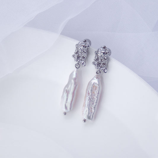Long drop earrings with natural Biwa baroque freshwater pearls on a white background