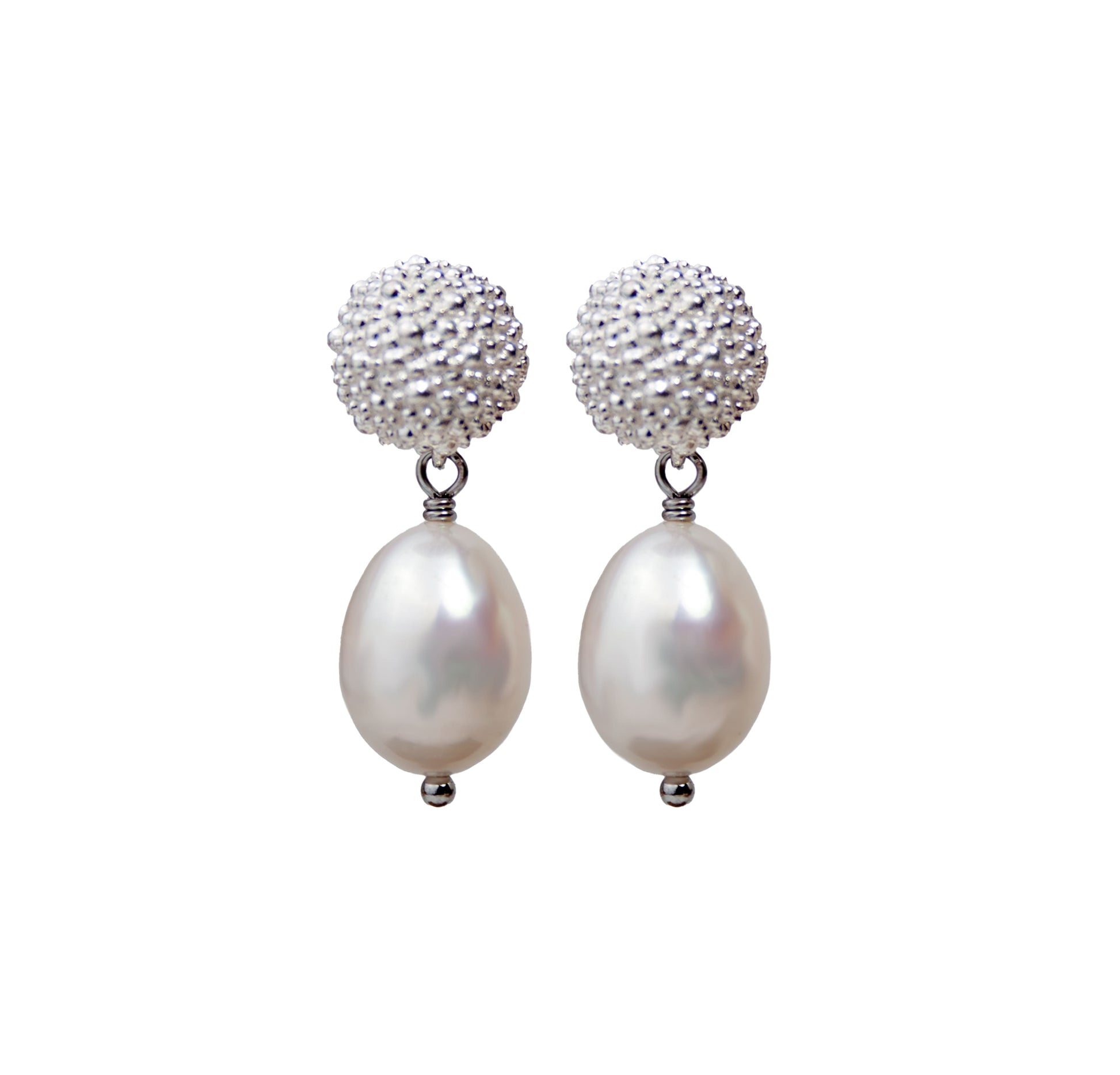 Pair of earrings with pearl drops and textured silver tops on a white background