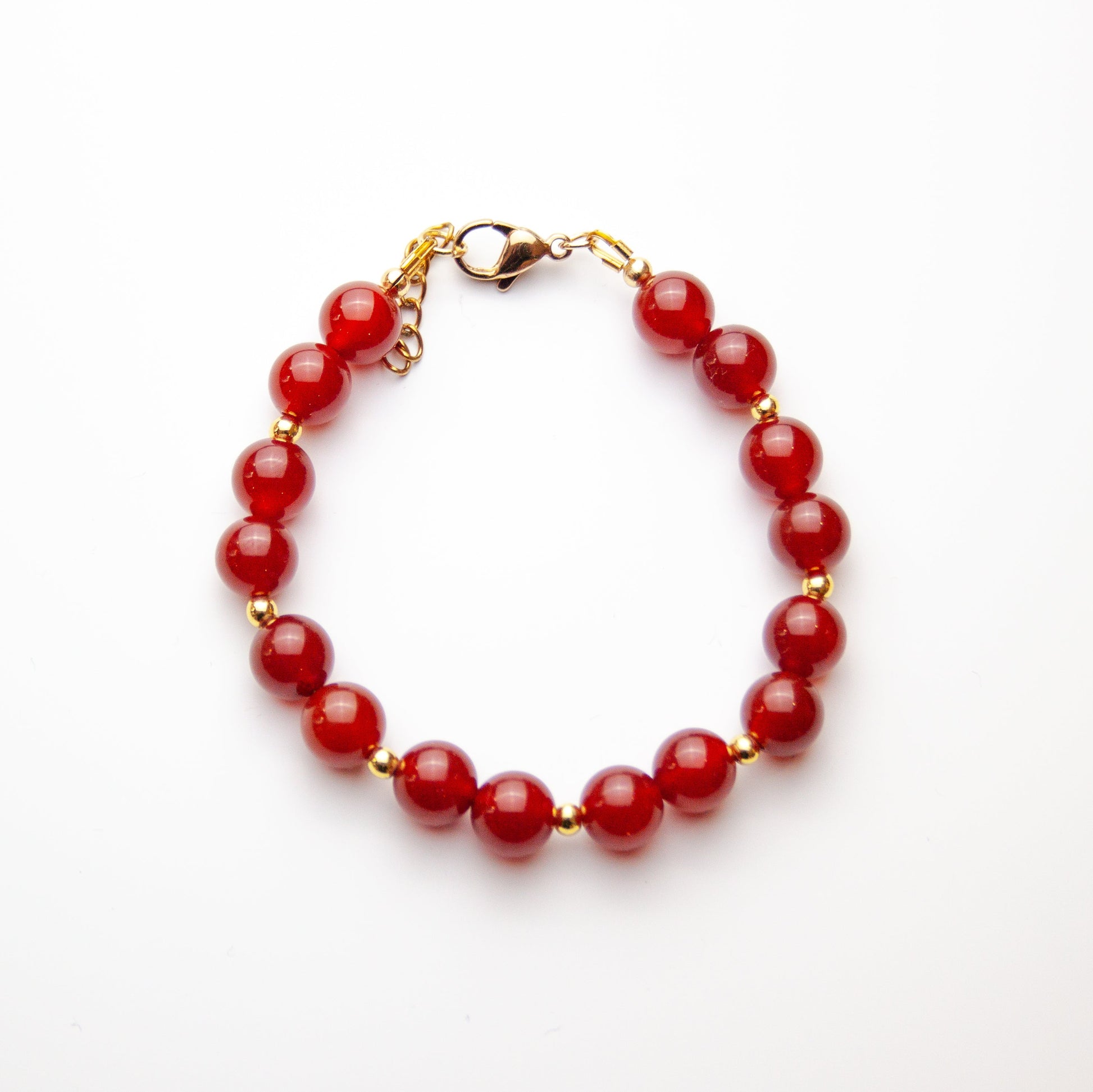 Carnelian bracelet with gold beads on white background